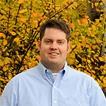 man standing in front of a tree