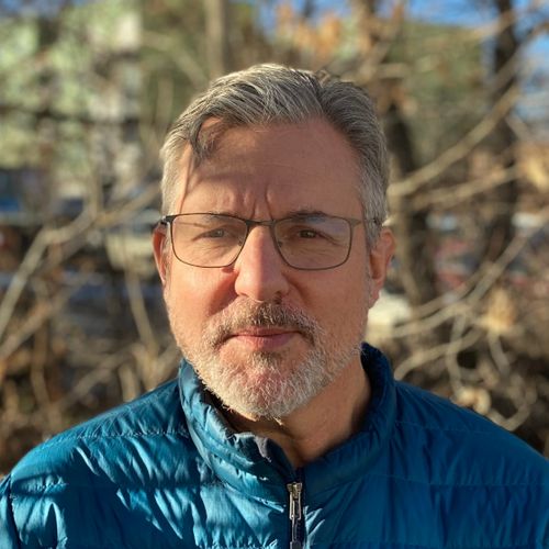 man wearing glasses and a blue jacket